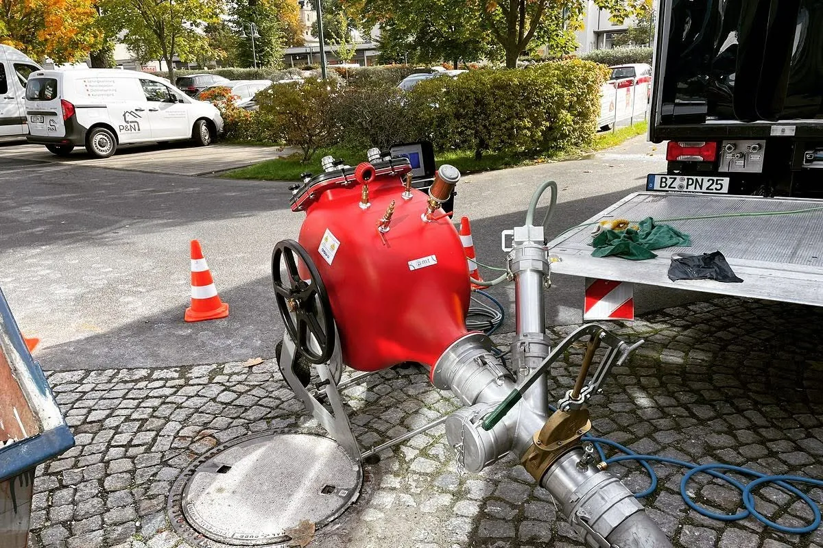 Einbautechnik für einen Schlauchliner der P&N Kanaltechnik GmbH an einem offenen Schacht im Kopfsteinpflaster